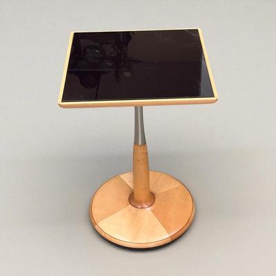 Sale Photo Thumbnail #5: Light Maple colored table with a black glass top.  Table has a round base with brushed metal band on the riser.  The serial number for this table is 052829.  The table was made in Italy. Please note the scratches in the black glass top.  Top is 17 3/4" sq