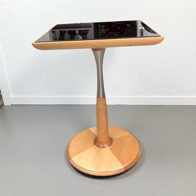 Sale Photo Thumbnail #4: Light Maple colored table with a black glass top.  Table has a round base with brushed metal band on the riser.  The serial number for this table is 052829.  The table was made in Italy. Please note the scratches in the black glass top.  Top is 17 3/4" sq