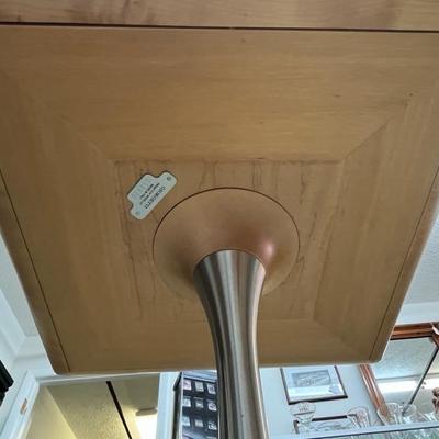 Sale Photo Thumbnail #6: Light Maple colored table with a black glass top.  Table has a round base with brushed metal band on the riser.  The serial number for this table is 052829.  The table was made in Italy. Please note the scratches in the black glass top.  Top is 17 3/4" sq