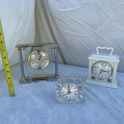 Sale Photo Thumbnail #103: 3 antique battery operated table clocks, selling as a set. Front clock is carved glass, approximately 3"x2"x3". Back left clock is set in glass with gold and silver accents, has "Mom & Dad" etched into gold plate beneath face, and is approximately 6"x1"x6