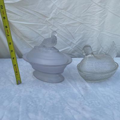 Sale Photo Thumbnail #128: Vintage glass dishes with bird lids, selling as set of 2. Could use a good scrub, but otherwise in great condition. Left dish is approximately 6"x4"x7" including foot and bird ornament with lightly frosted glass. Right dish is approximately 6"x4"x5".