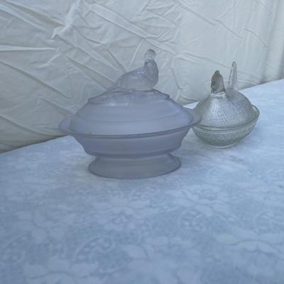Sale Photo Thumbnail #126: Vintage glass dishes with bird lids, selling as set of 2. Could use a good scrub, but otherwise in great condition. Left dish is approximately 6"x4"x7" including foot and bird ornament with lightly frosted glass. Right dish is approximately 6"x4"x5".