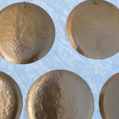 Sale Photo Thumbnail #140: 9 vintage Wendell August Forge Limited Edition Christmas Plates, years 1981-1988. Duplicates of 1985 and 1986, missing 1987. Various Christmas designs on solid brass plates with dimpled texture. In good condition and each plate has a small hook on the bac