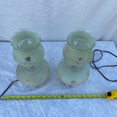 Sale Photo Thumbnail #150: Vintage mint green glass lamps, selling as a set of 2. Each takes a standard bulb and has a short cable ending in a 2 prong plug. Fair quality, color is slightly faded/dirty and the top piece of one lamp is chipped where it sits on the stem. Could use som