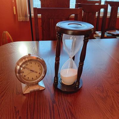 AN ART DECO STYLE ALARM CLOCK AND AN HOUR GLASS