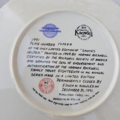Sale Photo Thumbnail #211: It was produced on fine china by the Edwin M Knowles China Company. 
The plate has a diameter of 8-1/4 inches. 
It features a festive scene of a man dressed as Santa's Helper with children and a dog. 
This plate is considered a collectible item, often fou