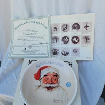 Sale Photo Thumbnail #219: Christmas 1988". 
Artist: Norman Rockwell, known for his American cultural depictions.
Manufacturer: Edwin M Knowles China.
Year of Issue: 1988, as indicated on the plate.