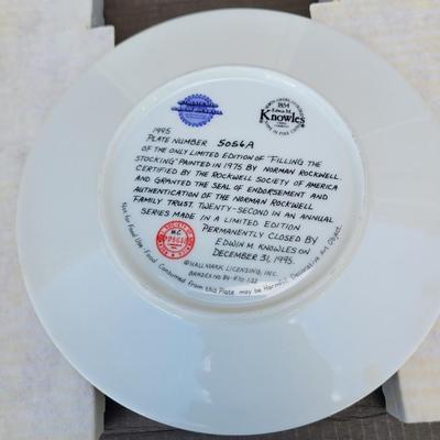 Sale Photo Thumbnail #342: Norman Rockwell "Filling The Stocking" collector plate from the 1995 Christmas series by Knowles. 
It is a limited edition plate, originally painted by Norman Rockwell in 1975, and certified by the Rockwell Society of America. 
The plate is part of an ann