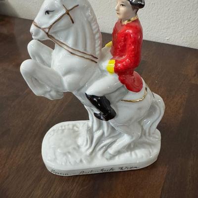 Porcelain Lipizzaner horse. A couple sitting on a bench.