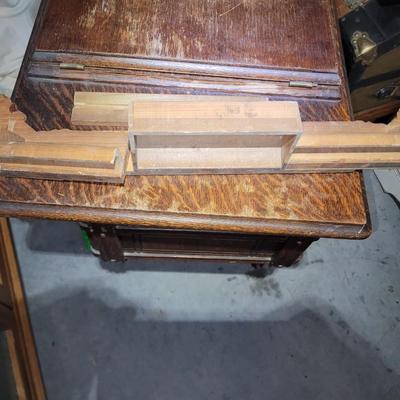 Sale Photo Thumbnail #790: Antique Singer Sewing Machine Table Plus Sewing Accoutrements (Lot of 4). Sewing machine with original table and foot pedal, cast iron and wood details. Also includes folding wooden box of different sewing feet, Singer buttonhole making foot, and pin cush
