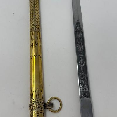 Sale Photo Thumbnail #184: E. Bonsman Solingen WWII German Navy officer dagger with intricate engravings on the blade, scabbard and hilt. There are emblems such as an anchor, eagle and swastika on the hilt of the dagger.