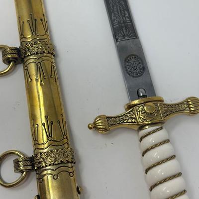 Sale Photo Thumbnail #179: E. Bonsman Solingen WWII German Navy officer dagger with intricate engravings on the blade, scabbard and hilt. There are emblems such as an anchor, eagle and swastika on the hilt of the dagger.