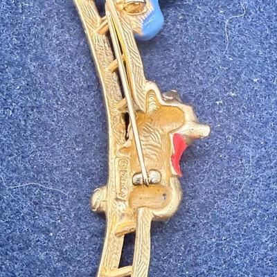 Sale Photo Thumbnail #460: This is a brooch/pin has Pooh climbing a ladder to reach a pot of honey. .It measures 1 inches  high x 2.5 inches wide. Very good condition.