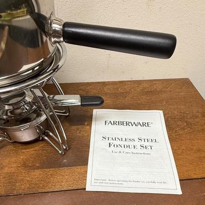 Sale Photo Thumbnail #177: 16 piece 18/8 stainless steel fondue pot set. Includes 6 forks, 6 black ceramic ramekins, splatter shield, adjustable universal burner with snuffer, stand and wood handle. In excellent condition.