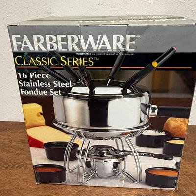 Sale Photo Thumbnail #176: 16 piece 18/8 stainless steel fondue pot set. Includes 6 forks, 6 black ceramic ramekins, splatter shield, adjustable universal burner with snuffer, stand and wood handle. In excellent condition.
