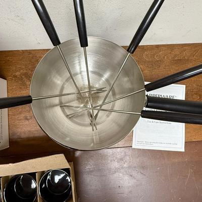 Sale Photo Thumbnail #179: 16 piece 18/8 stainless steel fondue pot set. Includes 6 forks, 6 black ceramic ramekins, splatter shield, adjustable universal burner with snuffer, stand and wood handle. In excellent condition.