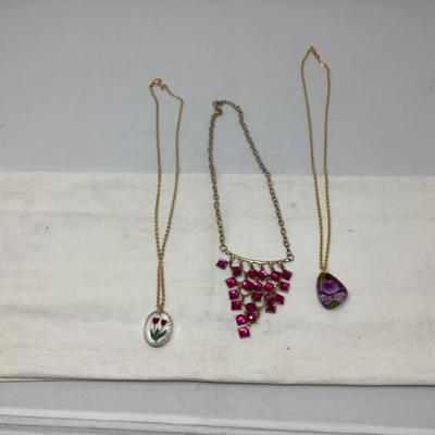 Sale Photo Thumbnail #246: You get three great gold necklaces.  Two have plastic flower pendants and the third has purple plastic gems.