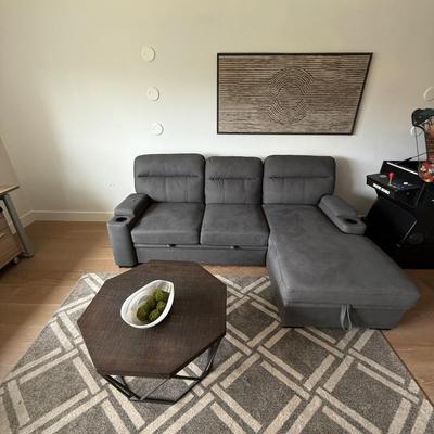 Sale Photo Thumbnail #20: The Kipling II Grey Sectional is a versatile addition to any living room, offering a seating capacity for three adults. This medium-firm sofa, upholstered in solid gray leather, features a high back and integrated cupholders for added convenience. The sec