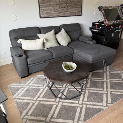 Sale Photo Thumbnail #19: The Kipling II Grey Sectional is a versatile addition to any living room, offering a seating capacity for three adults. This medium-firm sofa, upholstered in solid gray leather, features a high back and integrated cupholders for added convenience. The sec