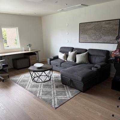 Sale Photo Thumbnail #23: The Kipling II Grey Sectional is a versatile addition to any living room, offering a seating capacity for three adults. This medium-firm sofa, upholstered in solid gray leather, features a high back and integrated cupholders for added convenience. The sec