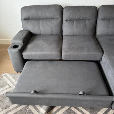 Sale Photo Thumbnail #21: The Kipling II Grey Sectional is a versatile addition to any living room, offering a seating capacity for three adults. This medium-firm sofa, upholstered in solid gray leather, features a high back and integrated cupholders for added convenience. The sec