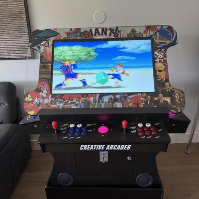 Sale Photo Thumbnail #24: The Creative Arcade Home Console offers Wi-Fi capability and displays in 720p HD resolution. It features a multicolor design and is manufactured in the United States. This pre-owned console is suitable for casual gaming sessions at home.