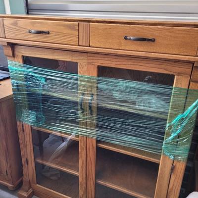 Sale Photo Thumbnail #856: Measures 48" wide, 19" deep and 57" tall. 4 shelves and two drawers, wrapped for storage and only slightly unwrapped for photos, will wrap further for transport. Oak
Doors are 21.5" wide and about 47" tall.