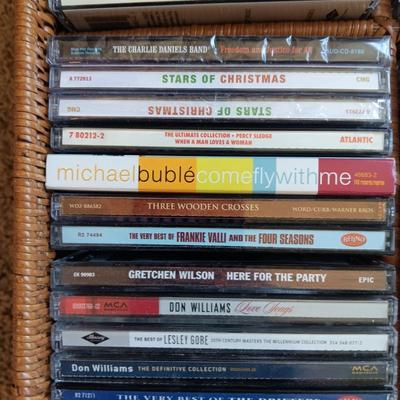 AN ASSORTMENT OF MAINLY COUNTRY WESTERN MUSIC ON CD AND A BASKET WITH A LID