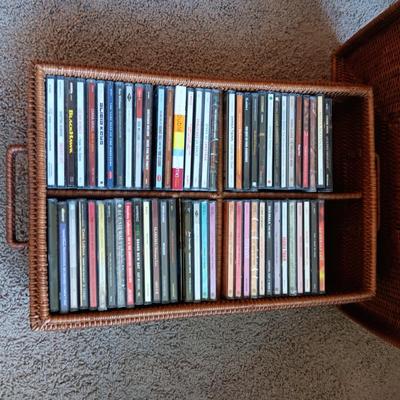 AN ASSORTMENT OF MAINLY COUNTRY WESTERN MUSIC ON CD AND A BASKET WITH A LID