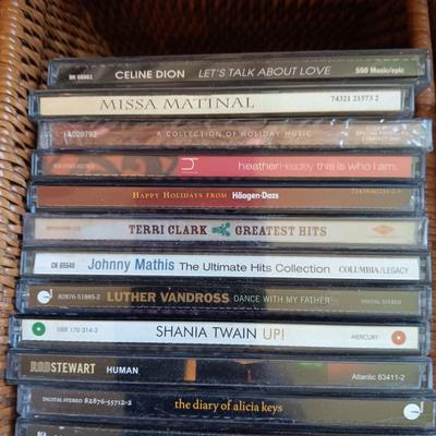 AN ASSORTMENT OF MAINLY COUNTRY WESTERN MUSIC ON CD AND A BASKET WITH A LID