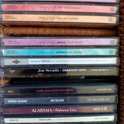 AN ASSORTMENT OF MAINLY COUNTRY WESTERN MUSIC ON CD AND A BASKET WITH A LID