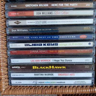 AN ASSORTMENT OF MAINLY COUNTRY WESTERN MUSIC ON CD AND A BASKET WITH A LID