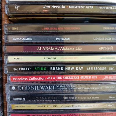 AN ASSORTMENT OF MAINLY COUNTRY WESTERN MUSIC ON CD AND A BASKET WITH A LID