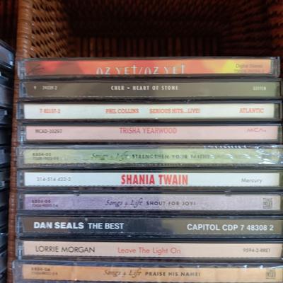 AN ASSORTMENT OF MAINLY COUNTRY WESTERN MUSIC ON CD AND A BASKET WITH A LID