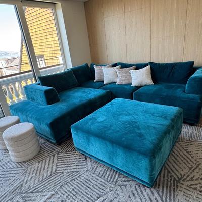 Sale Photo Thumbnail #47: The Interior Define sofa set in blue features a modern design with rich velvet upholstery, offering a spacious seating area suitable for more than six people. It includes a matching ottoman, making it ideal for living room gatherings or casual lounging. T