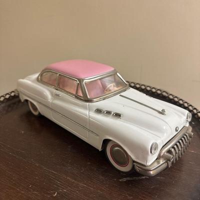 Old toy car Vintage Tin Friction Oldsmobile Promo car with pink roof/white body