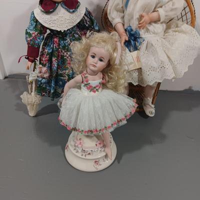 2 PORCELAIN DOLLS AND 1 MUSICAL ROTATING DOLL