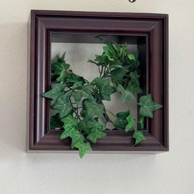 Three shadow box frames each containing artificial ivy.