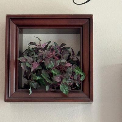 Three shadow box frames each containing artificial ivy.