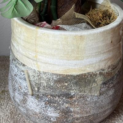 Large artificial plants in a decorative pot.