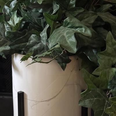 Two alto ceramic standing planters with artificial plants.