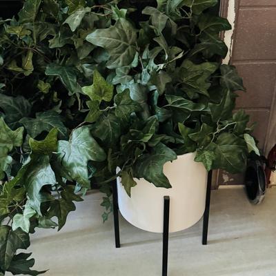 Two alto ceramic standing planters with artificial plants.