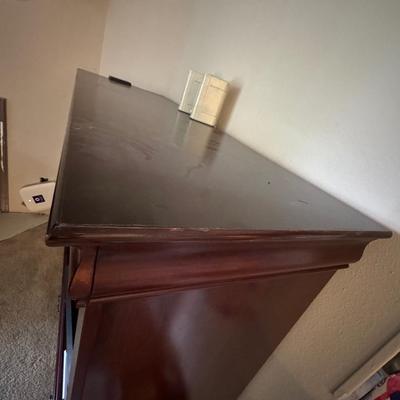 Large, dark wood entertainment center or TV stand.
