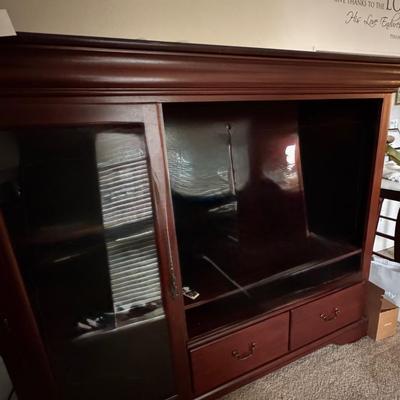 Large, dark wood entertainment center or TV stand.
