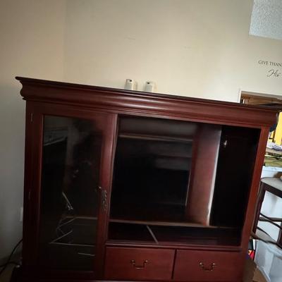 Large, dark wood entertainment center or TV stand.