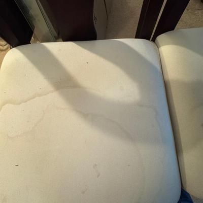 Two tall barstools, with seat covers.