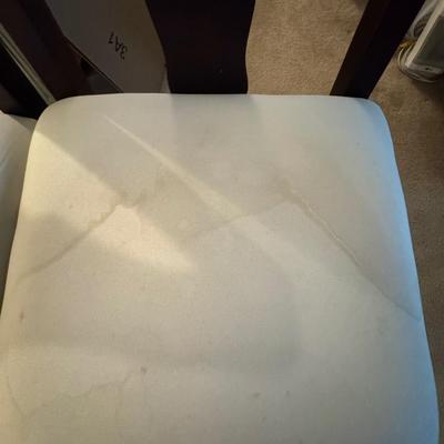 Two tall barstools, with seat covers.