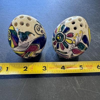Hand-painted, egg-shaped ceramic salt and pepper shakers.