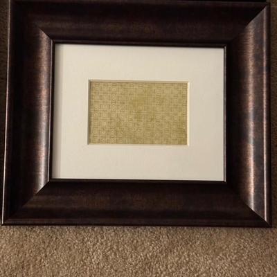 Six framed art pieces, likely decorative prints or patterns, housed in dark wood frames with white matting.