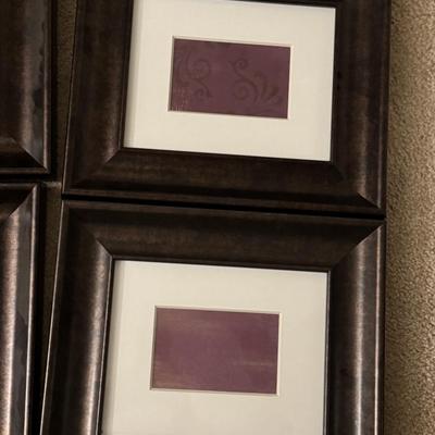 Six framed art pieces, likely decorative prints or patterns, housed in dark wood frames with white matting.